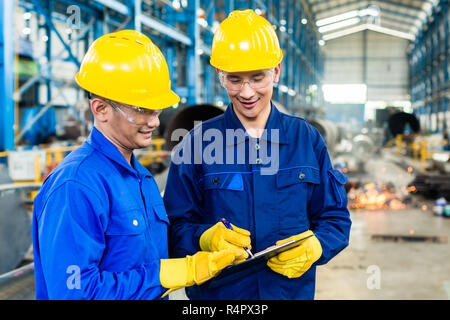 Two workers in production plant as team Stock Photo