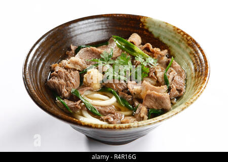 Bowl of ramen beef noodle with herbs on white background Stock Photo