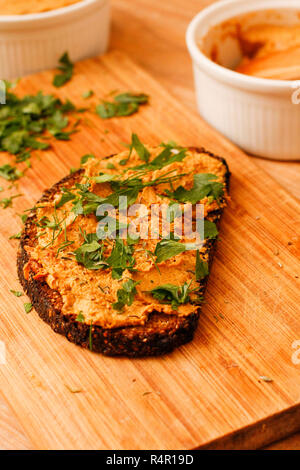 Chanterelle mushroom pate with black bread on wooden cutting board Stock Photo