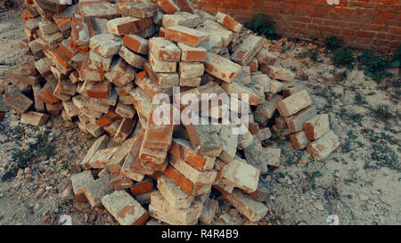 A stack of red clay bricks isolated on the floor Stock Photo