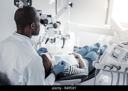 Attentive international dentist treating his young patient Stock Photo