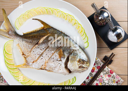 Grilled pompano fish on white dish Stock Photo