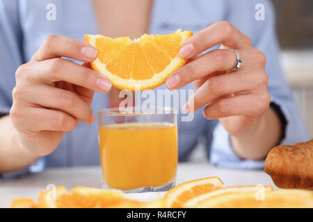 Female arms hold slides orange and glass of juice Stock Photo