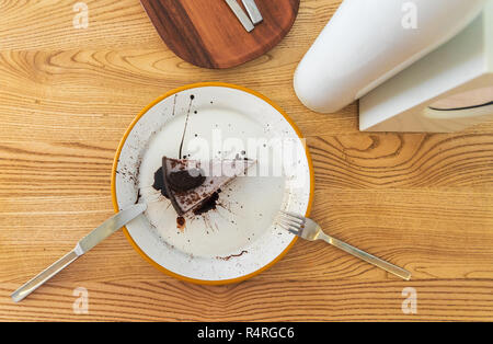 View from the top on a slice of cheesecake with half a chocolate chip cookie on top and sprinkles of chocolate topping Stock Photo