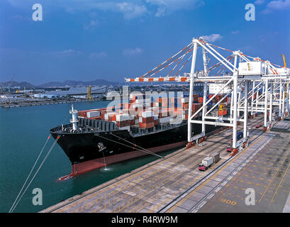 Cargo ship loading cargo into the ship in harbour aerial View Stock Photo