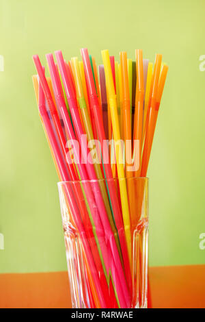 Colorful drinking straws in glass, close up. Color of the drinking straw. Bright colored straws for drinks. pile of plastic cocktail straws. Stock Photo