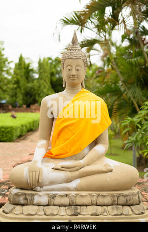 Sculpture of Buddha wearing yellow robe while meditating in Ayut Stock Photo