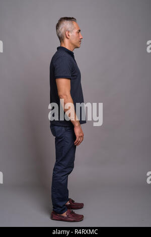 Full length profile view shot of handsome Persian man with gray hair Stock Photo