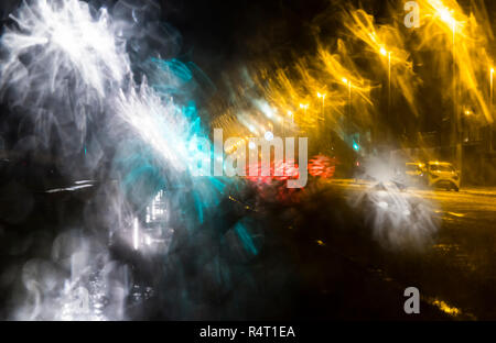 View through windscreen of cars driving in rain at night. Wet weather driving while raining. Stock Photo