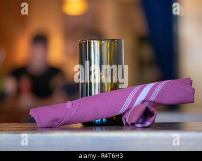 Various items on a restaurant table, napkins, candle, diners  Stock Photo
