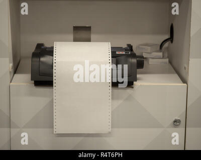 Printer sitting on shelf with overflowing blank white paper Stock Photo