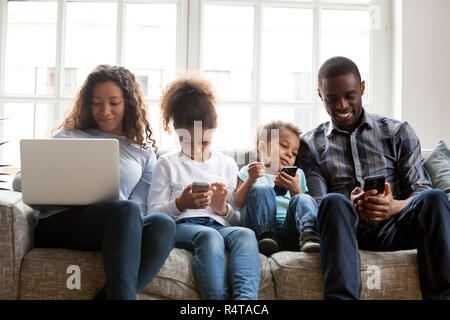 Large African American family using devices, sitting together Stock Photo