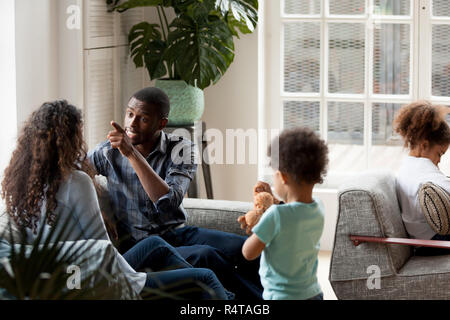 African American couple quarrelling at home on couch Stock Photo