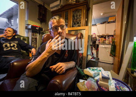 The needy and physically disabled Brian Glover, 59, smokes with friends in his apartment in a Nottingham hostel. He is a needy at Foodbank at Hope House in the Beeston United Reformed Church Nottingham. Stock Photo