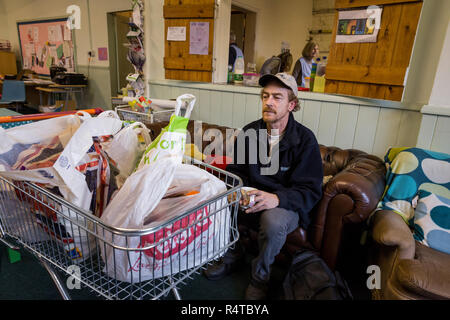 Tony Lee, a needy family man, is looked after by volunteer helpers at the Arnold Food Bank Daybrook Baptist Church's food store in Nottingham and provided with donated food for his family. Stock Photo