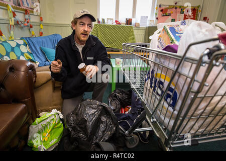 Tony Lee, a needy family man, is looked after by volunteer helpers at the Arnold Food Bank Daybrook Baptist Church's food store in Nottingham and provided with donated food for his family. Stock Photo