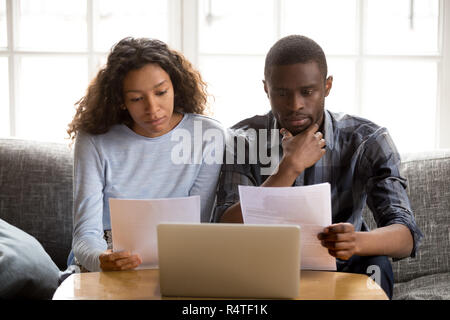 Serious African American couple reading paper documents Stock Photo