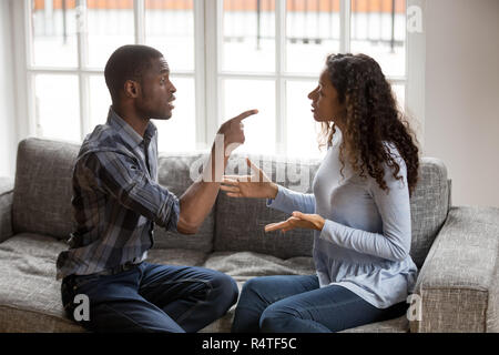 Irritated African American couple quarrelling at home Stock Photo