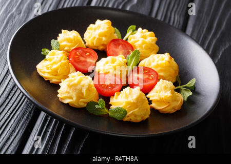 Appetizing snack Duchess Potatoes closeup on a black plate on a wooden table. horizontal Stock Photo