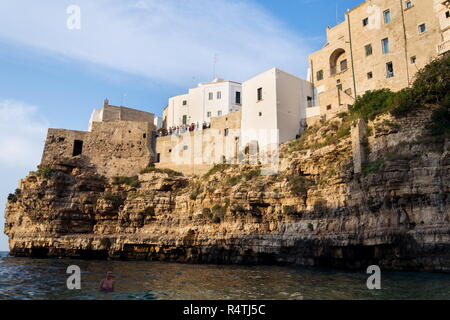 POLIGNANO A MARE, ITALY - JULY 6 2018: Tourist looking from view in historic center to lovely beach Lama Monachile, Adriatic Sea, Apulia, Bari provinc Stock Photo