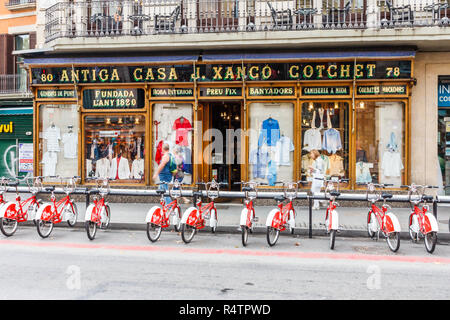Barcelona, Spain - 4th October 2017: Bicycles parked outside clothing shop on Las Ramblas. The street is  very famous pedestrianised shopping area. Stock Photo