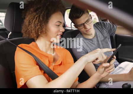 Young couple using smart phone GPS in car Stock Photo
