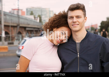 Portrait affectionate young couple on urban sidewalk Stock Photo