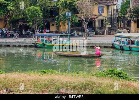 Hoi An a traditional Vietnamese lady rowing a boat across the river Bon in Hoi An Town Vietnam. Stock Photo