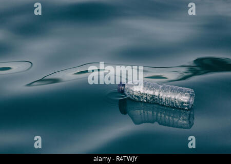 Plastic water bottle floating on water surface Stock Photo