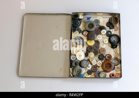 A close up view of a old metal box with differnt size and colour buttons on a isolated white background Stock Photo