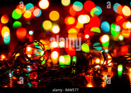Blurred christmas or fairy lights christmas decoration background, focus on electric light bulbs Stock Photo