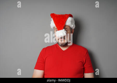 christmas hater hiding face behind santa hat Stock Photo