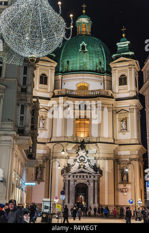 Vienna, Austria - December 24, 2017. St. Peter's Church or Peterskirche with Christmas decoration and illumination in evening. Illuminated baroque Rom Stock Photo