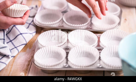 https://l450v.alamy.com/450v/r4wgkx/lining-metal-muffin-pan-with-paper-cupcake-liners-to-bake-blueberry-muffins-r4wgkx.jpg