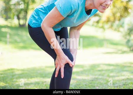 Senior sporty woman has  knee pain while workout Stock Photo