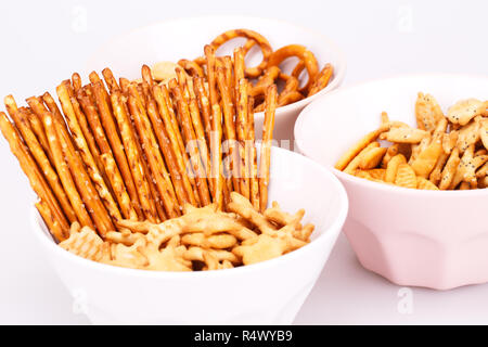 Different salted crackers in bowls on white background. Stock Photo