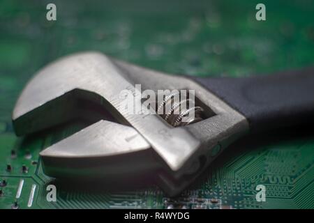 Close up adjustable spanner wrench on a green electronics board, use the right tool concept image Stock Photo