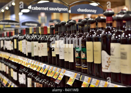 Wine bottles on shelves in supermarket Stock Photo