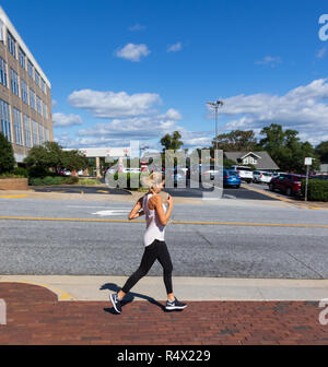 HICKORY, NC, USA-10/13/18: Young woman running on city street. Stock Photo