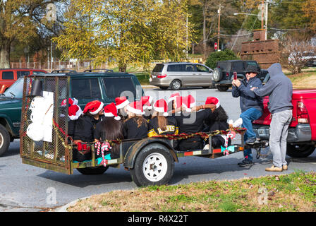 LINCOLNTON, NC, USA-11/25/18: Man taking picture of a trailer filled with young women heading to be in a Christmas parade. Stock Photo