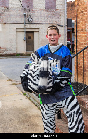 LINCOLNTON, NC, USA-11/25/18: Young man in zebra costume hold head in hands, getting ready for parade. Stock Photo