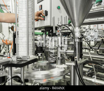 production and bottling of yogurt in plastic cups. equipment at the dairy plant Stock Photo