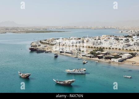 Bay with traditional wooden Dhow ships. Coastline of old city Sur in Sultanate of Oman. Stock Photo