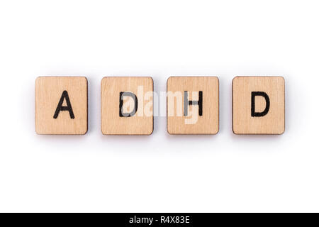 The abbreviation ADHD - Attention Deficit Hyperactivity Disorder - spelt with wooden letter tiles. Stock Photo