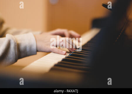 children's hands on the piano keys, rehearsal music, learning to play the piano. Stock Photo