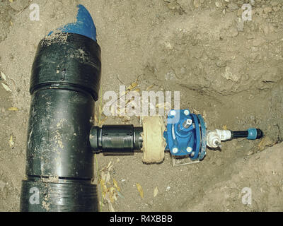 Pipes of PVC large diameter  prepared for laying on construction site.  Colorful thick wall plastic pipe, blue light and red circle end cover Stock Photo