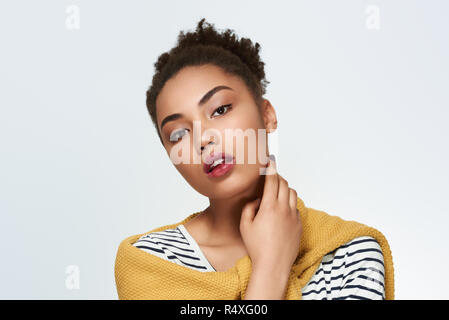 Young woman studio isolated in white touching face looking camer Stock Photo