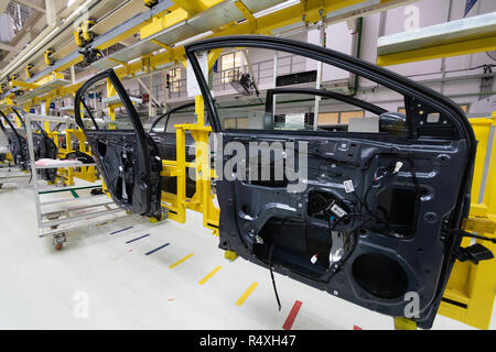 car door on conveyor. Robotic equipment makes Assembly of car. Modern car Assembly at factory Stock Photo