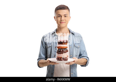 Teenage boy holding a pile of donuts on a plate and looking at the camera isolated on white background Stock Photo