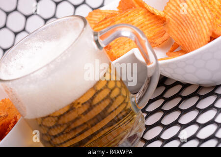 Glass of light beer and potato chips on a abstract background Stock Photo